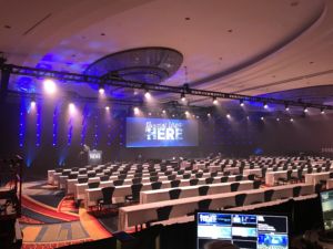 Corporate event stage with immersive blue branding and lighting design.
