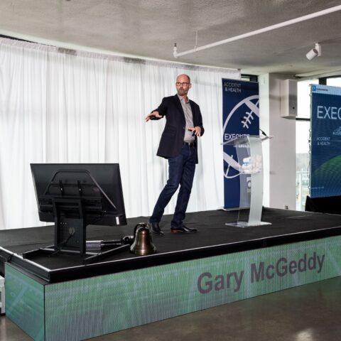Dynamic stage design for corporate events showcasing vibrant lighting and brand integration.