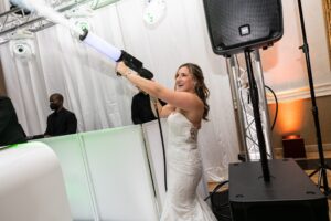 Bride using CO2 blasters at a personalized wedding, having fun.