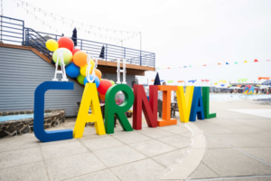 A carnival-themed setup for a corporate event, featuring colorful balloons and bold signage, offering a unique event theme idea.