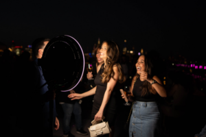 Attendees enjoying a photo booth at a corporate event, using interactive props for a fun, memorable experience.