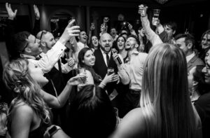 Wedding MC leading the crowd in a toast during a reception.
