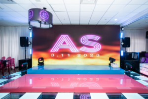Vibrant LED dance floor and large digital backdrop at a bat mitzvah, creating a colorful and dynamic party atmosphere.