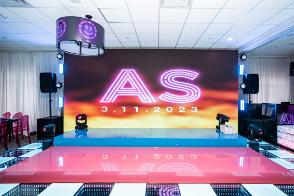 Vibrant LED dance floor and large digital backdrop at a bat mitzvah, creating a colorful and dynamic party atmosphere.