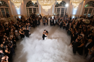 Bride and groom first dance on the clouds at their wedding reception.