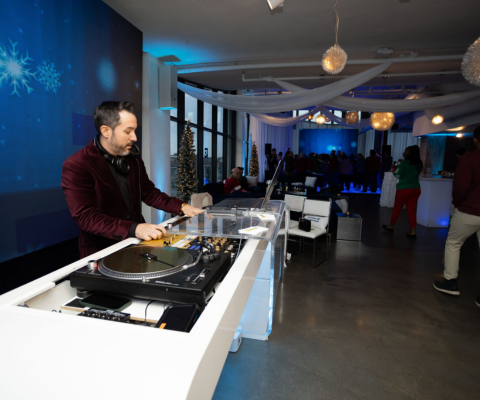 DJ mixing tracks at an event using professional equipment.