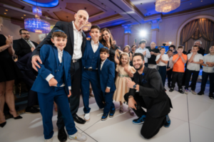 Family celebrating together at a bar mitzvah, sharing pride in the boy's religious milestone.