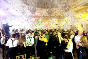 Wedding guests celebrate the couple’s last dance with vibrant confetti filling the room.