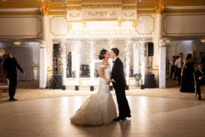 Bride and groom share their last dance for wedding with sparkling fireworks in the background