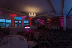 Romantic wedding reception setup with neon sign and chandeliers