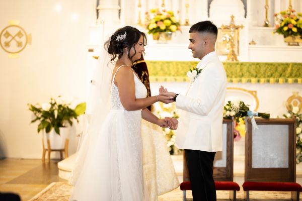 A bride and groom exchange vows and rings in a beautifully decorated church.