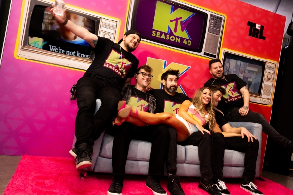 Guests posing at TRL-inspired MTV backdrop.