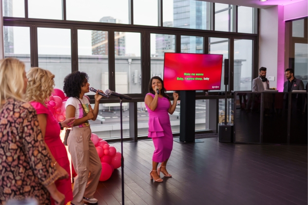Group singing karaoke with lyrics displayed on a large LED screen.