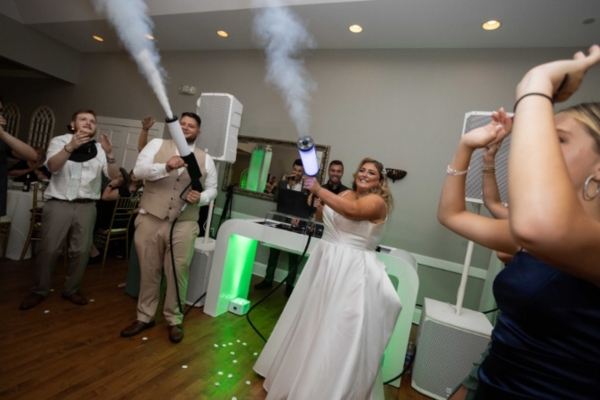Bride and groom celebrating with a DJ at their wedding reception.