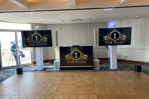 TV DJ booth setup with screens displaying wedding branding.
