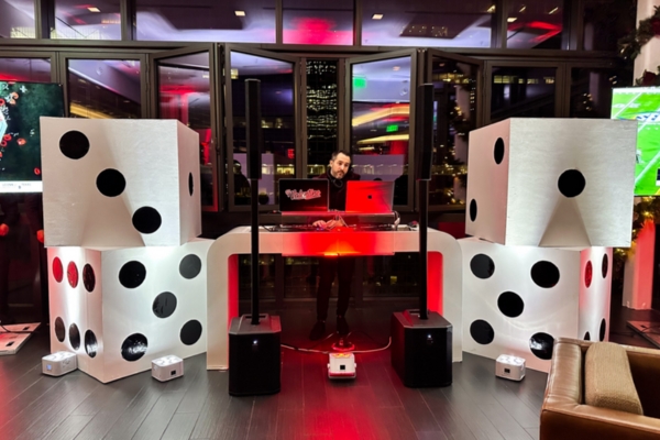 DJ stage with dice speakers and red lighting.