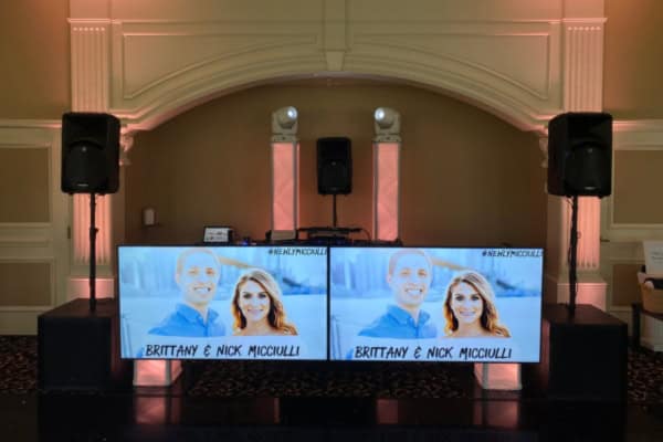 Custom-branded DJ booth with couple’s names and images.