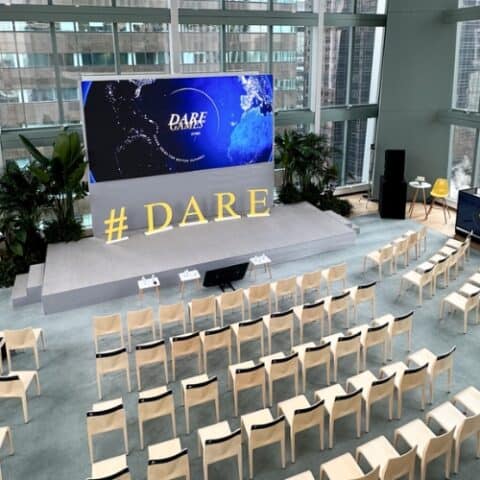Corporate event stage with branded visuals and LED screen.