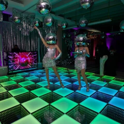 LED dance floor with futuristic performers at a themed event.