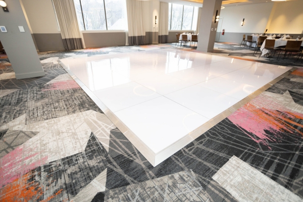Glossy white static wedding dance floor in hotel ballroom