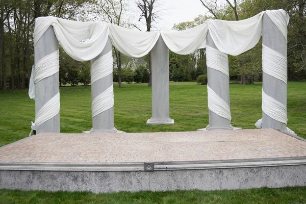 Roman themed party stage with columns and drapery
