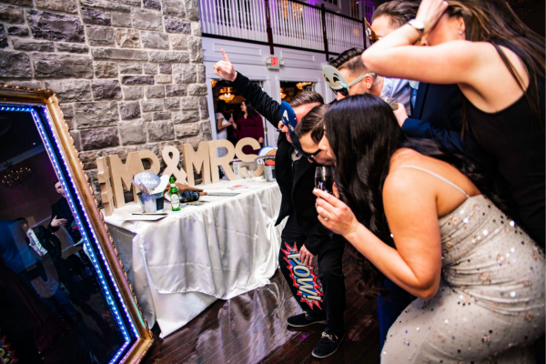 Guests using a mirror photo booth at a wedding