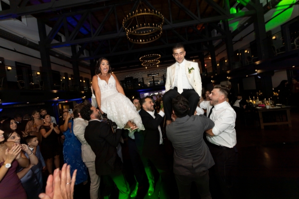 bride and groom lifted by guests