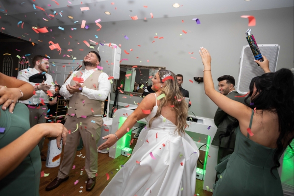 Bride and guests celebrating with DJ for wedding reception
