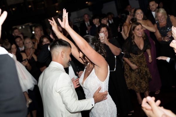 Newlyweds dancing surrounded by guests