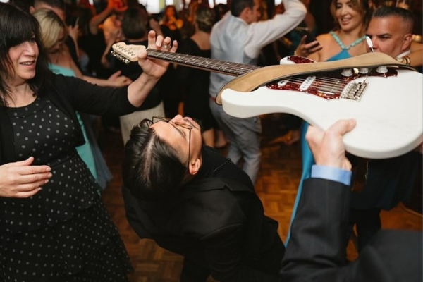 Guests dancing with live wedding guitarist.