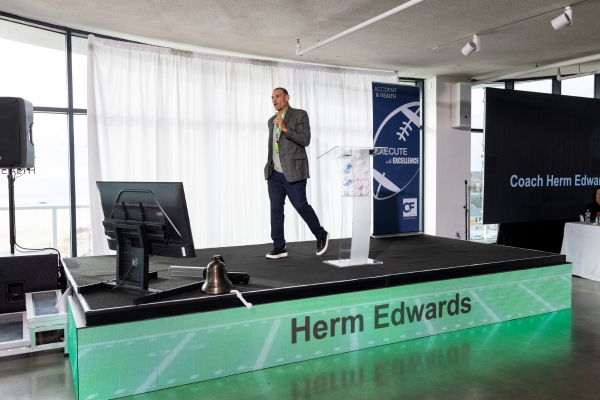 Speaker on LED stage at award ceremony.