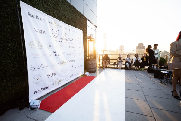 White sponsor step and repeat backdrop with red carpet