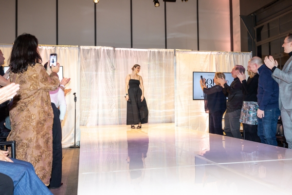 Model walking on white thrust stage